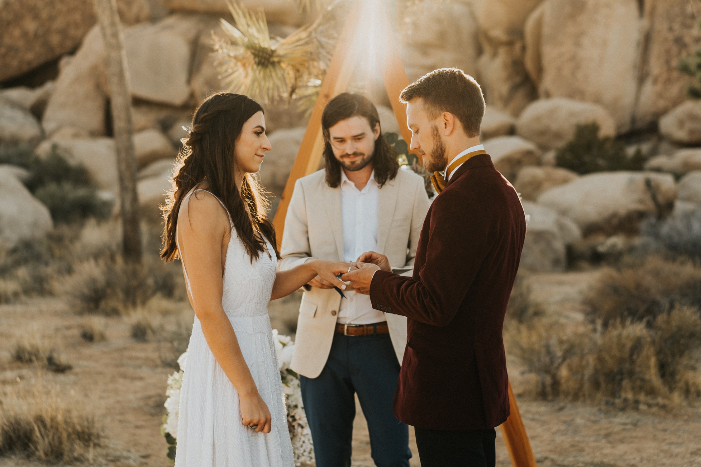 A couple is exchanging rings during their Joshua Tree elopement ceremony.